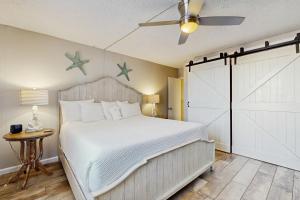 デスティンにあるDolphin Point 105Aのベッドルーム1室(白いベッド1台、納屋のスライドドア付) +25枚の写真