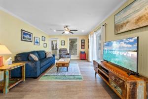 a living room with a blue couch and a flat screen tv at Bay Leave in Gulf Shores