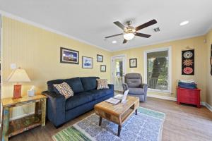 a living room with a blue couch and a ceiling fan at Bay Leave in Gulf Shores +29 photos