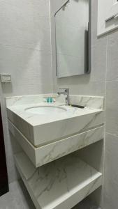 Un baño con un lavabo blanco y un espejo. en Inter Town Hotel, en Salalah
