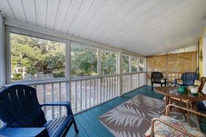 a screened in porch with chairs and a table at Bay Leave in Gulf Shores