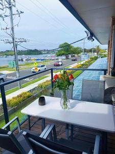 a table with a vase of flowers on a balcony at Lakeside Motel Waterfront in Lakes Entrance +19 photos