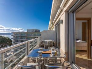 a balcony with tables and chairs on a building at Vue Mer - Neuf - Centre Ste Maxime in Sainte-Maxime