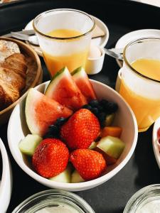 Boutique camping Whanau, verwarmde tenten في Rutten: طاولة عليها وعاءان من الفاكهة وكوبان من العصير