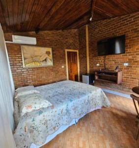 una camera da letto con un letto e un muro di mattoni di Casa amanhecer a Triunfo Altre 23 foto