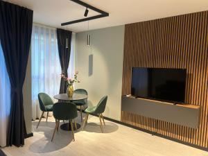 ein Wohnzimmer mit Fernseher und Tisch und Stühlen in der Unterkunft Apart Hotel Danaya in Stara Sagora