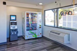 Una máquina expendedora junto a un enfriador de bebidas en una tienda en Super 7 Inn by Hotel O Dallas I 20, en Dallas