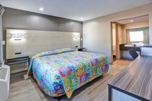 una habitación de hotel con una cama y un baño en Super 7 Inn by Hotel O Dallas I 20, en Dallas