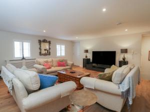 a living room with couches and a flat screen tv at Flat 6 in Tetbury