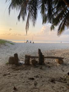 a bench on a beach with the ocean in the background at Blue Waves Apartments in Mombasa