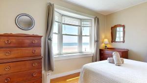 een slaapkamer met een bed, een ladekast en een raam bij Sandy Beach at Star Board in Surfside