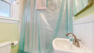 een badkamer met een wastafel en een douchegordijn bij Sandy Beach at Star Board in Surfside