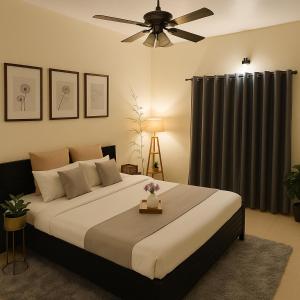 a bedroom with a large bed with a ceiling fan at Meraki - Entire 2BHK Villa With Himalayan Views in Rānīkhet