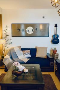 a living room with a blue couch and a table at Meraki - Entire 2BHK Villa With Himalayan Views in Rānīkhet