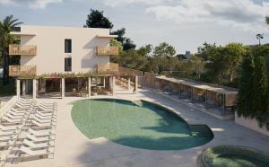 a swimming pool in front of a building at Canyamel Sun Suites Hotel in Canyamel