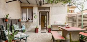 a patio with a table and benches and a house at Ca`del Fuin in Seregno