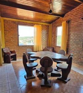 una sala da pranzo con tavolo e sedie in legno di Casa amanhecer a Triunfo
