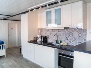 Una cocina con gabinetes blancos y un fregadero. en Lofoten Bed & Breakfast Reine - Rooms & Apartments, en Reine