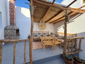 a patio with a couch and a table and a fireplace at Atlantic refuge rooms in Essaouira
