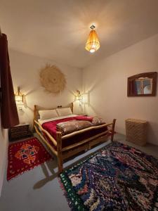 a bedroom with a wooden bed and a rug at Atlantic refuge rooms in Essaouira