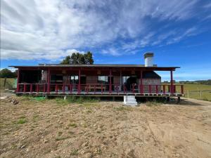 ein kleines Haus mit einer Veranda auf einem Feld in der Unterkunft Chiloé,Curaco de Velez casa de veraneo in Curaco de Velez