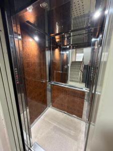 een glazen douche in een kamer met een spiegel bij Shkodra Apartment in Shkodër