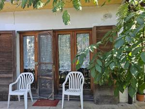 twee witte stoelen op de veranda van een huis bij La Casa di Sandhya in Udine +2 foto's