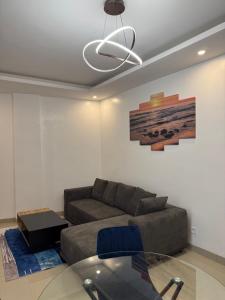 Una sala de estar con un sofá y una mesa de cristal. en Sublime T2 Lumineux et Calme, en Dakar