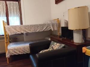 ein Wohnzimmer mit einer Couch und einem Etagenbett in der Unterkunft La Casa di Sandhya in Udine