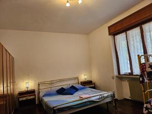 ein Schlafzimmer mit einem Bett mit blauen Kissen darauf in der Unterkunft La Casa di Sandhya in Udine