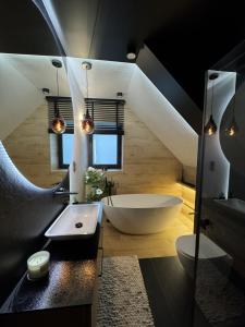 een badkamer met een groot wit bad en een wastafel bij Willa Black Wood in Istebna