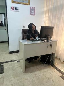 a woman sitting at a desk with a laptop at Glovis Hospitality in Abuja +50 photos
