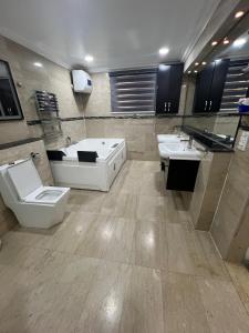a bathroom with two sinks and a toilet and a tub at Glovis Hospitality in Abuja