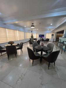 a restaurant with tables and chairs in a room at Glovis Hospitality in Abuja