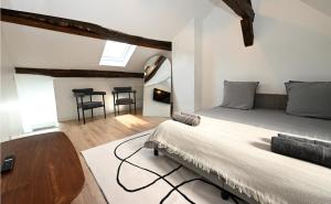 ein Schlafzimmer mit einem Bett, einem Tisch und Stühlen in der Unterkunft Le Sens - Duplex 4 pers - Love Room - Jacuzzi in Sens