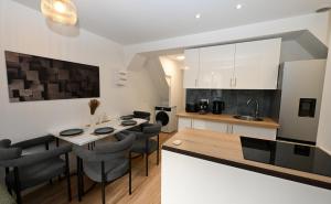 eine Küche und ein Esszimmer mit Tisch und Stühlen in der Unterkunft Le Sens - Duplex 4 pers - Love Room - Jacuzzi in Sens + 20 Fotos