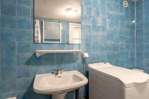 La salle de bains est pourvue de carrelage bleu, d'un lavabo et de toilettes. dans l'établissement Edelweiss - Grust, Panoramique Sud, à Grust 16 autres photos