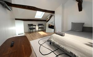 ein Schlafzimmer mit einem Bett, einem Tisch und Stühlen in der Unterkunft Le Sens - Duplex 4 pers - Love Room - Jacuzzi in Sens