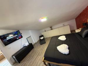 Atena B&B APARTMENTS Imperial في San Silvestro: غرفة نوم مع سرير وتلفزيون بشاشة مسطحة