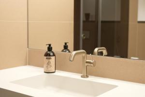 CASA ROMA Hostel Boutique في تاراغونا: مغسلة الحمام عليها زجاجة صابون +23 صورة