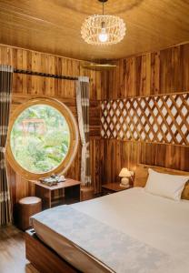 Trang An Maison Retreat في Nguyên Ngoại: غرفة نوم بسرير ونوافذ دائرية