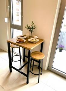 a wooden table with two plates of food on it at Cozy studio avec balcon aux portes de Genève in Ambilly