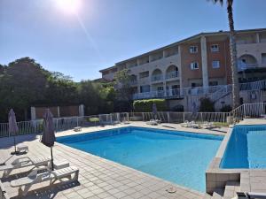 a swimming pool in front of a hotel at Studio climatisé avec piscine à ST FLORENT in Saint-Florent