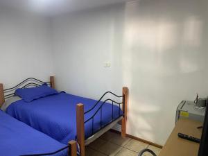 a bedroom with two twin beds and a desk at Alojamiento Puente Alto in Santiago +24 photos