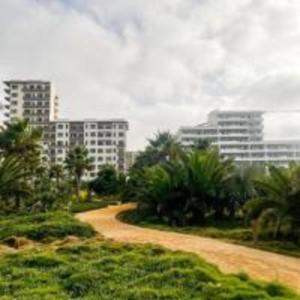 a dirt road in front of some tall buildings at Luxury Studio in a secured residence in Aïn Harrouda
