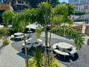 een groep picknicktafels en een palmboom bij Camping&Cafe in Pattaya South