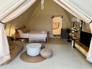 een kamer met een tent met een bed en een bank bij Camping&Cafe in Pattaya South