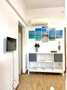 un salon avec une télévision et un mur blanc dans l'établissement A due passi dal mare, à Montesilvano