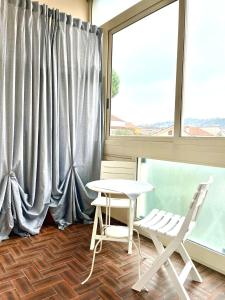 une table et deux chaises dans une pièce avec une fenêtre dans l'établissement A due passi dal mare, à Montesilvano 12 autres photos