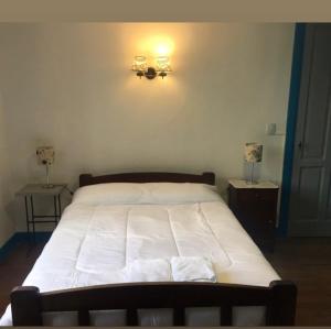 a bedroom with a large white bed with lights on the wall at Munay Posada in Los Cocos +2 photos